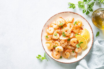 Shrimps with spices in craft plate at white stone table. Top view with space for text.