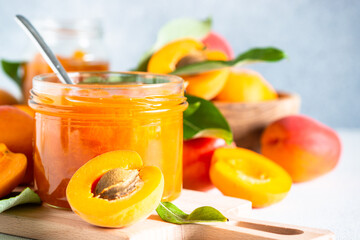 Apricot jam in glass jar with fresh apricots. Homemade preservations.