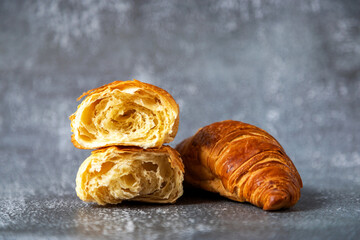 Fresh and juicy croissants on a cutting board on a dark background. Place for text. Fresh bakery