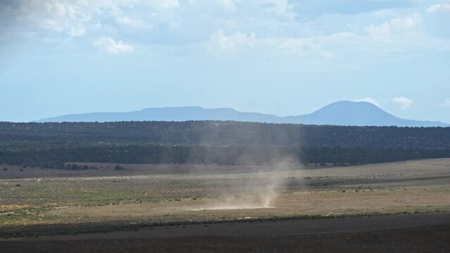 Dust devil moving through the Utah desert in slow motion as it spirals and kicks up dirt.