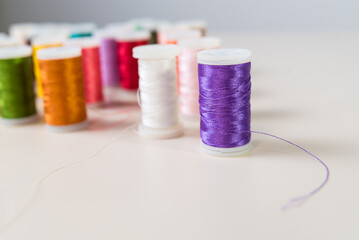 violet, close-ups of colored threads, dressmaker, atelier, seamstress, sewing clothes, embroidering fabric, needle and thread, selective focus