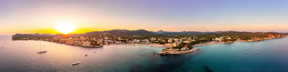 Fototapeta na wymiar Panorama Aussicht auf die Küste von Mallorca, Cala Fornells und Paguera bei Sonnenuntergang, Aerial view with drone, skyline at sunset, summer at mediterranean sea