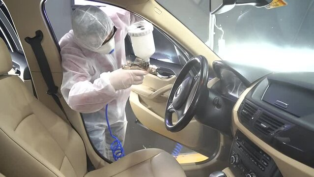car interior disinfection, Clean surfaces in the car with disinfectant spray, corona virus