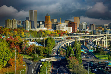 Downtown city of Portland Oregon with fall color trees and a  freeway interchange in foreground