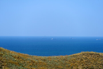 Seascape overlooking hills with dry grass