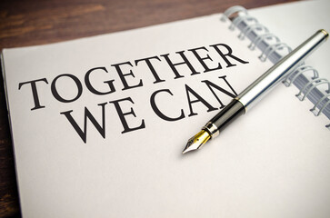 TOGETHER WE CAN text written on notebook with pen