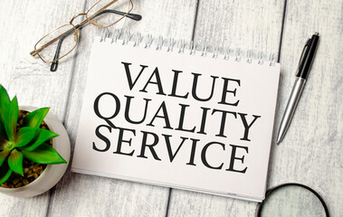 value quality service words on notepad and pen, calculator and glasses
