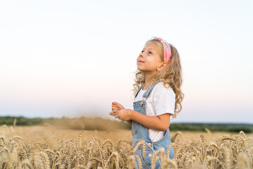 a little blonde curly girl running in a wheat field, the concept of human freedom