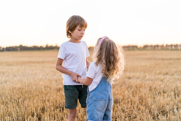 Happy and free people, children run through the beveled field of wheat