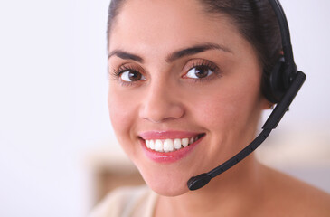 Portrait of beautiful business woman working at her desk with headset and laptop