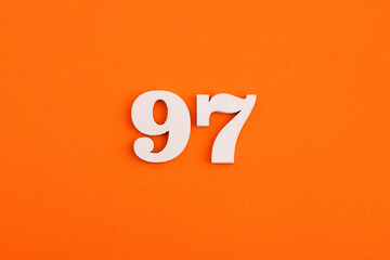 White wooden number 97 on eva rubber orange background