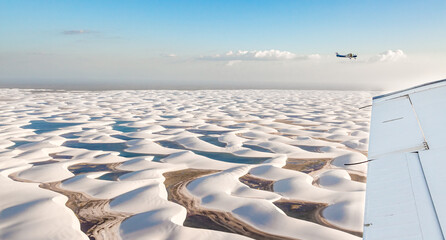 airplane flying over white sand dunes of Lencois Maranhenses