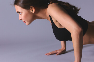 Fototapeta na wymiar Portrait of young woman doing push ups