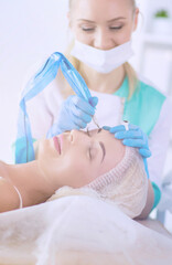 Naklejka premium Permanent makeup for eyebrows. Closeup of beautiful woman with thick brows in beauty salon