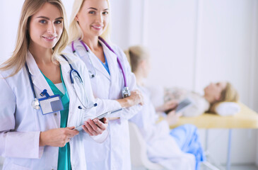 Portrait of confident female doctors standing with arms crossed at the medical office