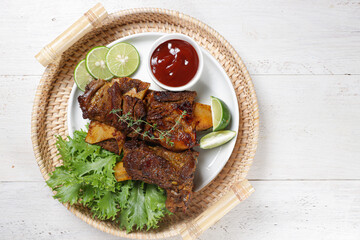 Iga Bakar Madu or Honey Roasted Ribs served with sauce.