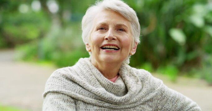 Happy, excited and joyful senior woman enjoying nature outdoors in a backyard of a retirement home. Portrait of a mature and old pensioner sitting outside in the garden and feeling healthy