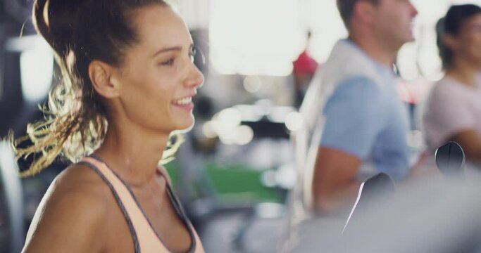 Fitness, happy and sporty woman doing a cardio workout while rinning on a treadmill and smiling at the camera. Athletic, fit and real people being active and training together at a health club