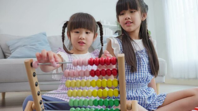 Asian young girl sibling playing toys together in living room at home. 