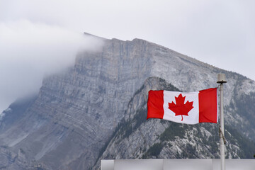 Canadian flag with Rocky Mountains in the background