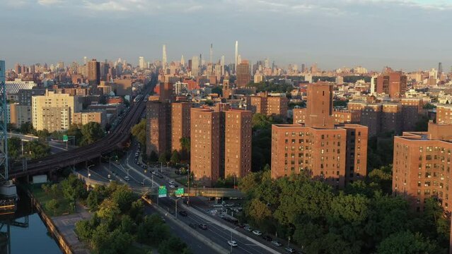 Cinematic aerial pull back from Harlem NYC with Midtown Manhattan in the distance