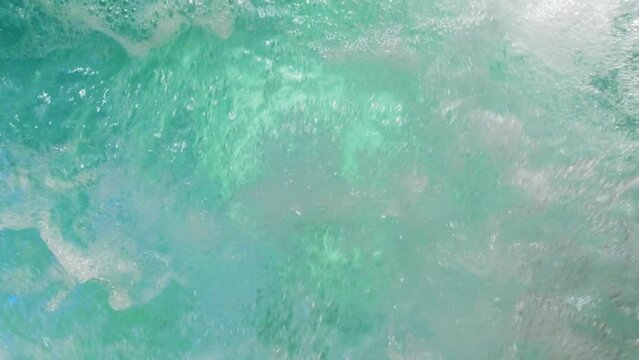 Slow motion shot of air bubbles coming out to the surface of a jacuzzi pool water