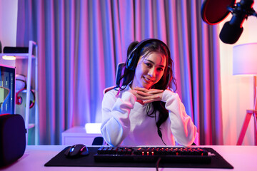 Portrait of Asian Esport woman gamer playing video game on computer. 