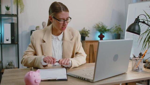 Businesswoman works on laptop analyzing financial graph decrease loses becoming surprised sudden results bad news fortune loss fail at office. Irritated angry freelancer girl breaking pencil in hands