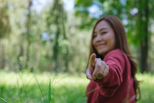 Blurred image of a woman touching or pointing finger at you in the park