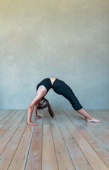Fototapeta na wymiar A young girl in sportswear does yoga, fitness at home, sports at home, stretching