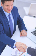 Business people shaking hands, finishing up a meeting, in office