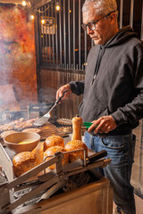 Man preparing hamburgers in a barbecue