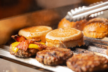 Grill with cheeseburgers with bacon and bread