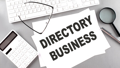 DIRECTORY BUSINESS text on paper with keyboard, calculator on grey background
