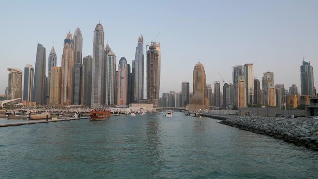 Dubai Marina sunset cruise with tall buildings and skyscrapers in background.