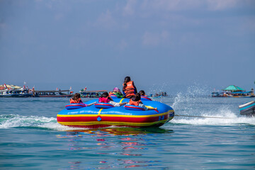 Fototapeta premium People riding banana boats while traveling to the beach