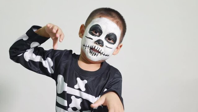 Halloween Kid. Portrait of Asian little kid boy wearing skeleton costume studio shot isolated white background, Child man horror face painting make up for scary, Happy halloween day concept