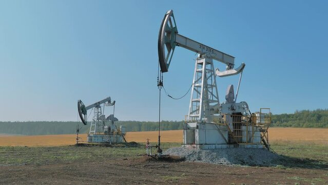 Pumping rigs extracting oil from an oil well in vast oil field. Oil Industry Equipment.