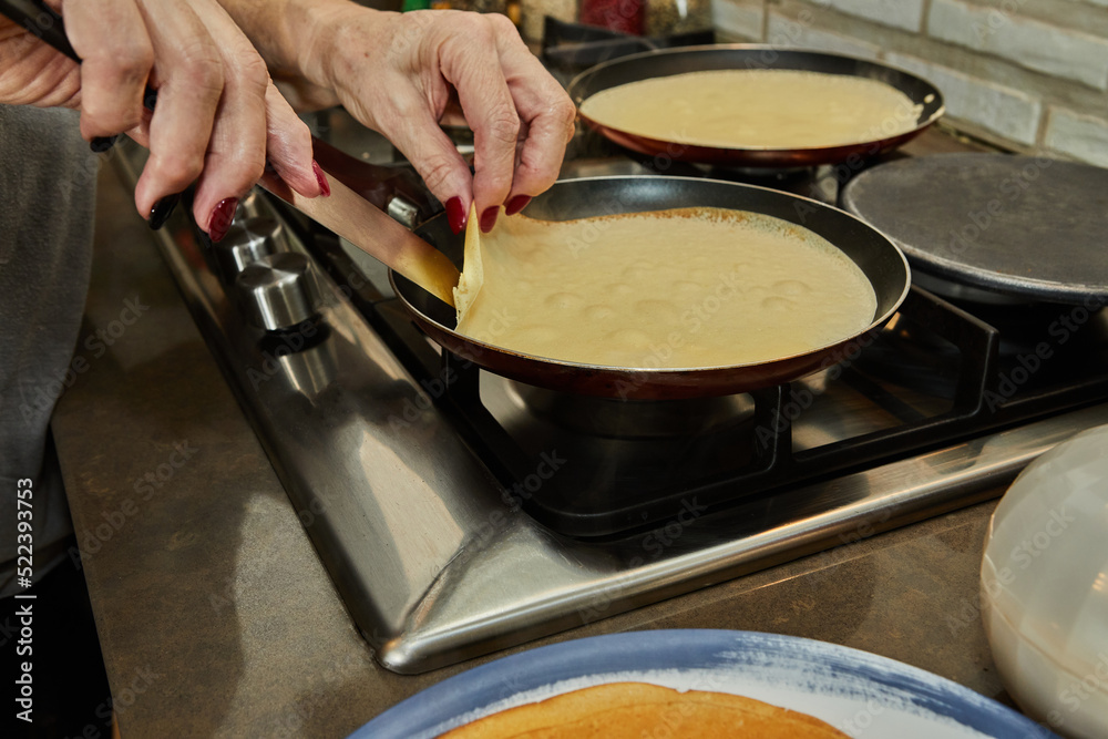 Wall mural Chef pan-frying Crepe Suzette pancakes with cognac and citrus sauce