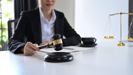 Close up view female judge or lawyer holding a gavel in hand. Lawyer, justice and law and attorney concept