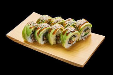 The Green Dragon roll is laid out on a wooden stand on a black isolated background