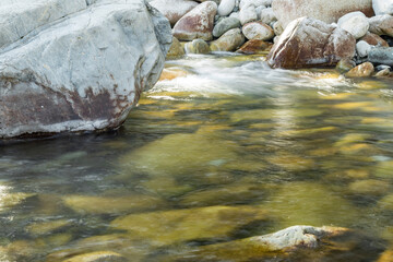 a transparent stream flows between white stones