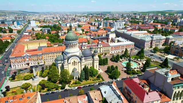 Aerial drone view of The Orthodox Cathedral located on the Avram Iancu Square in the centre of Cluj Napoca, Romania. Cityscape, central square, old buildings, cars