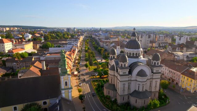 Aerial drone view of Ascension of the Lord Cathedral in the centre of Targu Mures, Romania. Old buildings, greenery, roads with cars