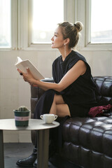 fashion Asian beauty sitting in couch reading book indoors