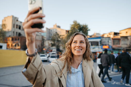 Young woman taking selfie on smartphone in the street