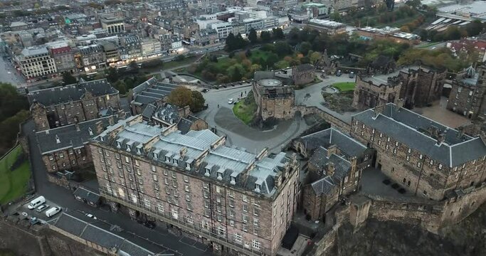 An impressive drone shot looking down on Edinburgh castle and panning up to see Arthur's seat in the distance at sunset.