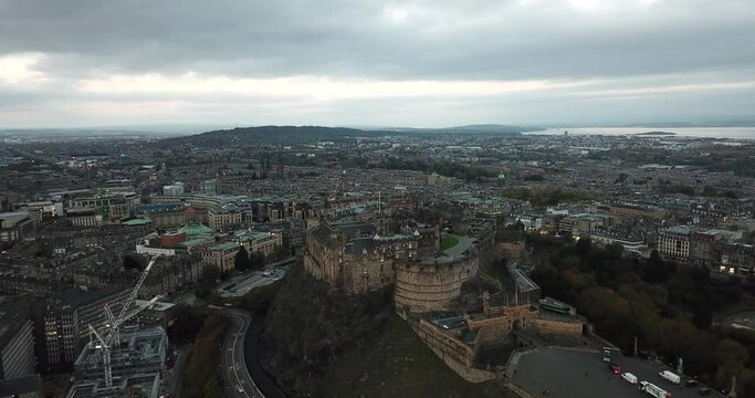 Impressive drone shot high above Edinburgh castle, slowly moving towards it from Arthur's seat and finishing looking down into the castle courtyard.