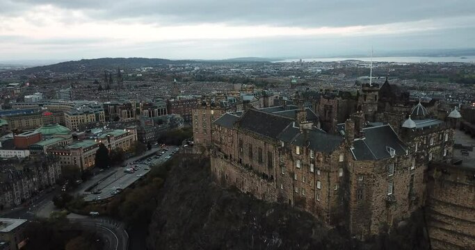 Incredible drone shot of Edinburgh castle from the south side. Starts above the castle looking out over the city, and slowly lowers down to see the castle's impressive structure at sunset.