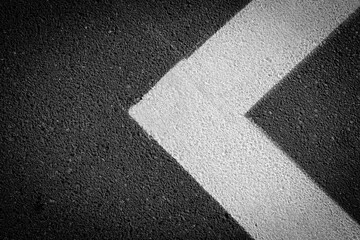 Grey asphalt with white street marks like a arrow, asphalt texture background